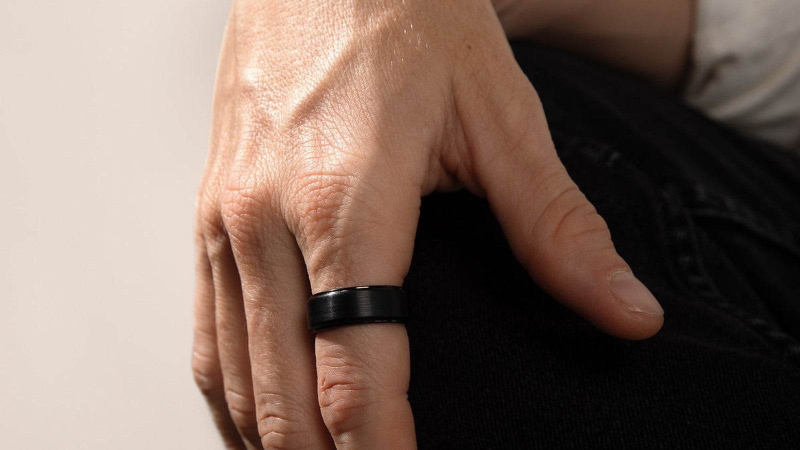 black tungsten carbide wedding band on a man's hand — FoundryCut Monolith
