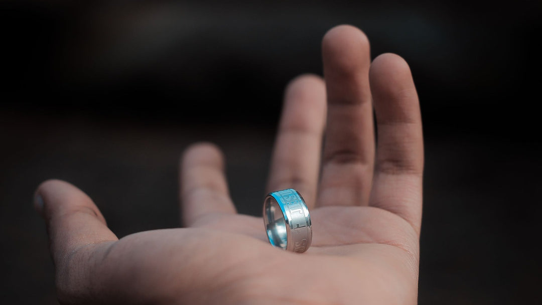 Tungsten vs ceramic ring comparison — a wide silver men’s band held in an open palm — FoundryCut