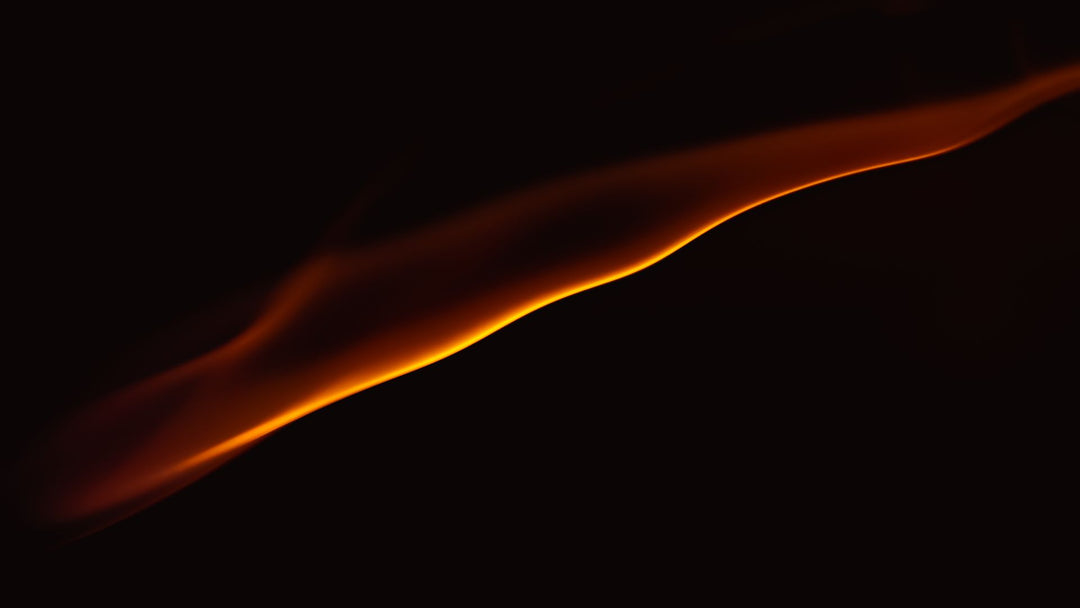 An abstract curved ribbon of orange and gold flame glowing against a near-black background
