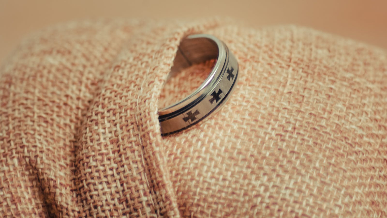tungsten vs stainless steel ring — masculine silver wedding band on natural fabric — FoundryCut