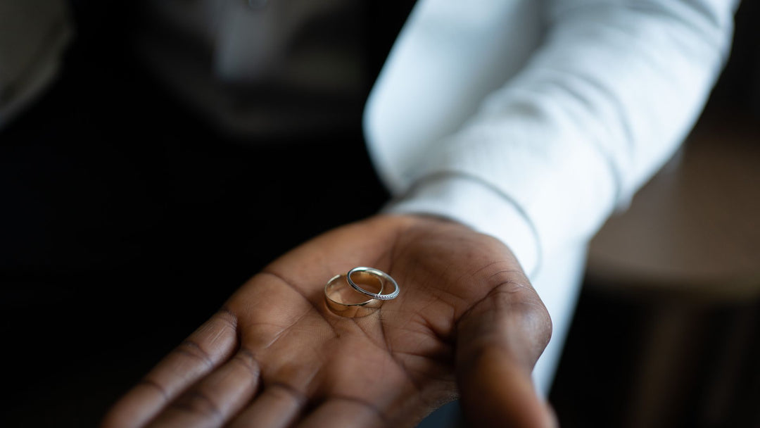 Men's wedding band ideas: a man holding two wedding bands in his palm