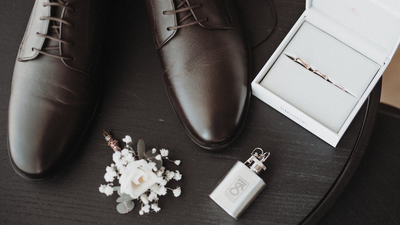 which hand do men wear wedding ring — groom flat lay with plain wedding bands — FoundryCut