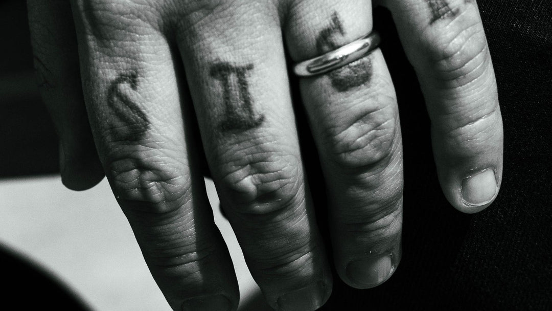 men's wedding ring tattoo — knuckle tattoos and a plain band on a man's hand — FoundryCut