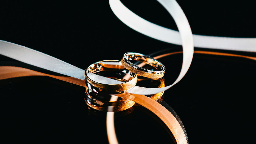 gold tungsten rings on a black background