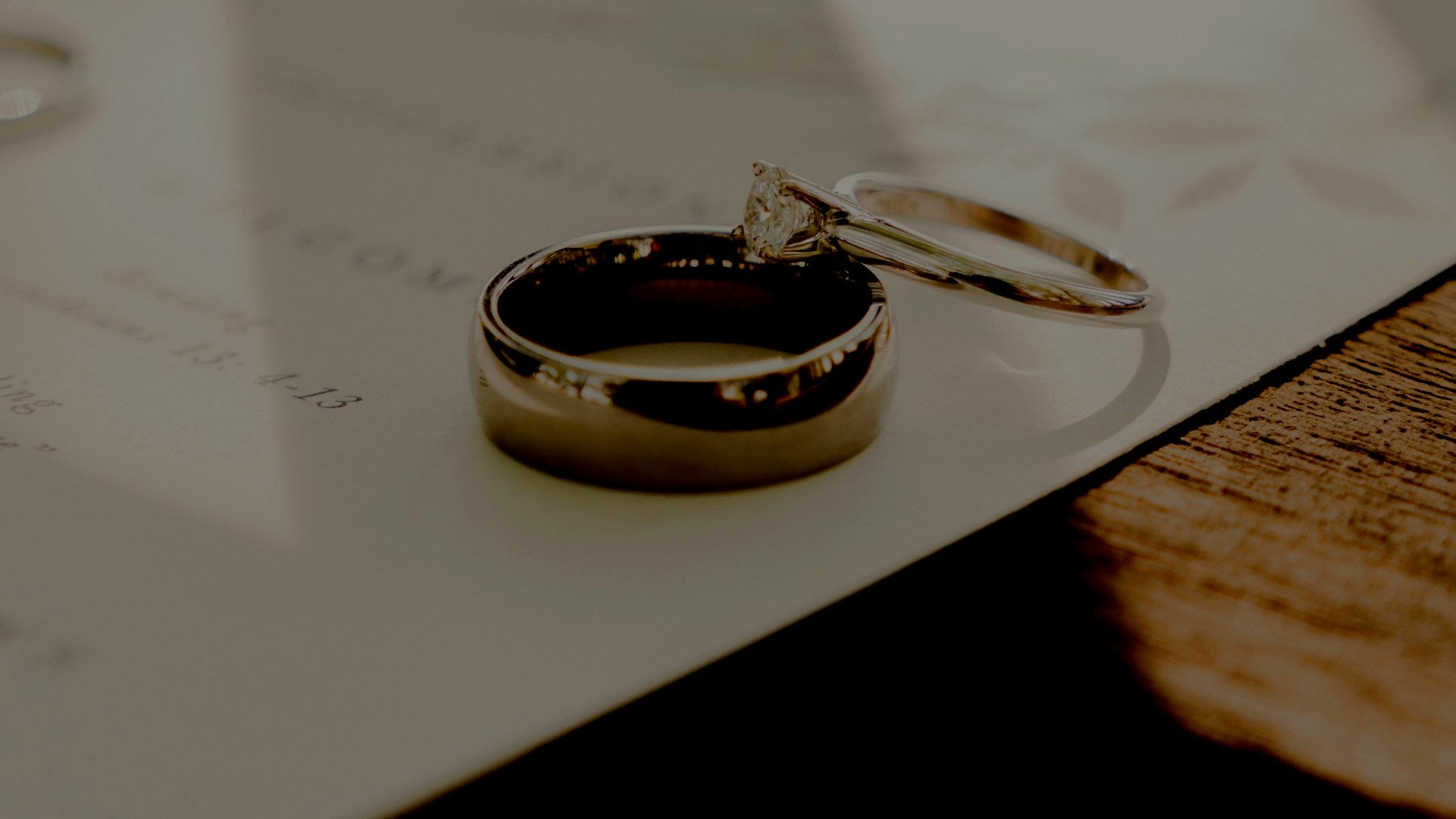 wedding ring vs wedding band — a plain men's wedding band beside a stone-set engagement ring