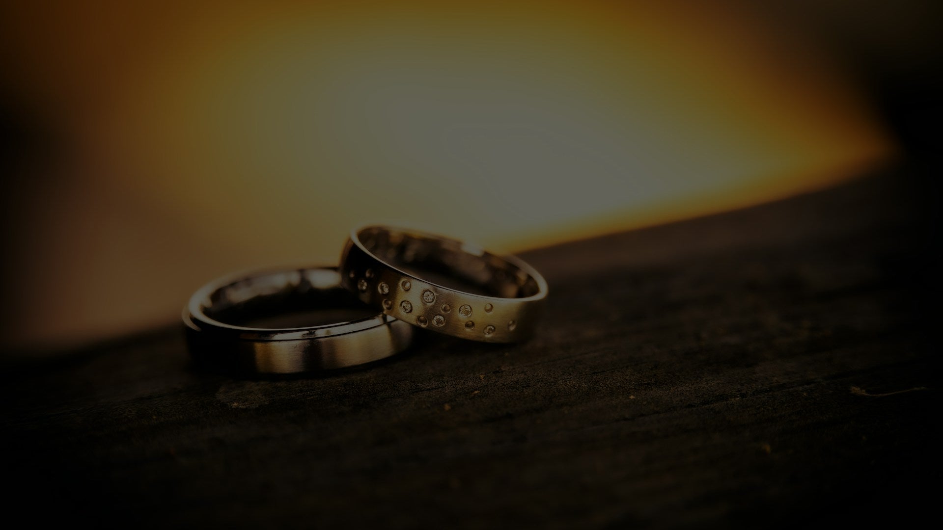 his and hers wedding bands shown as a matched pair of bands on dark wood